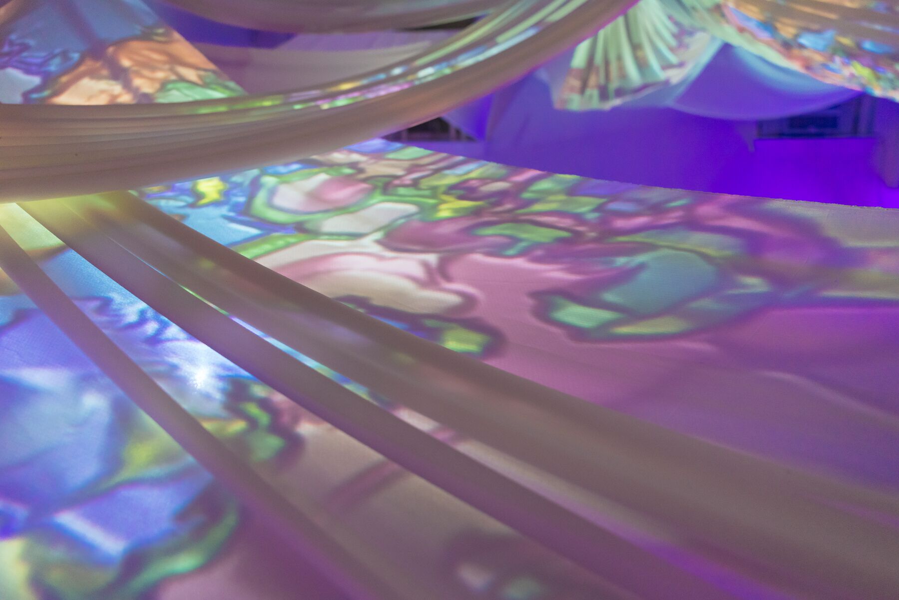Projected color moving across the draped ceiling fabric above AVA.